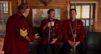 Movie still from “Super Troopers 2” (2018), directed by Jay Chandrasekhar – A group of men in red uniforms are drinking coffee; Medium shot, Over the shoulder angle