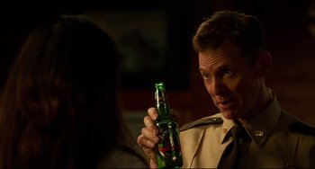 Movie still from “Super Troopers 2” (2018), directed by Jay Chandrasekhar – A man holding up a beer in front of a woman; Close Up shot, Over the shoulder angle