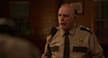 Movie still from “Super Troopers 2” (2018), directed by Jay Chandrasekhar – An older man wearing a uniform and a neck tie; Close Up shot, Over the shoulder angle