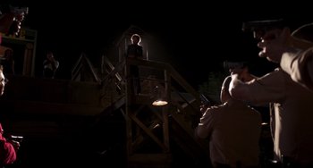 Movie still from “Super Troopers 2” (2018), directed by Jay Chandrasekhar – A man standing on top of a wooden platform; Wide shot, Low angle