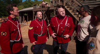 Movie still from “Super Troopers 2” (2018), directed by Jay Chandrasekhar – A couple of men standing next to each other on top of a hill; Medium shot, Over the shoulder angle