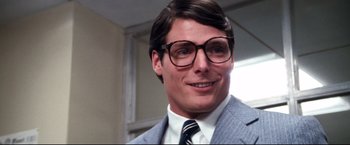 Movie still from “Superman II” (1980), directed by Richard Lester – A person wearing glasses and a suit; Close Up shot, Over the shoulder angle