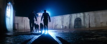Movie still from “Superman II” (1980), directed by Richard Lester – A group of people and two dogs walking down a street; Wide shot, Low angle