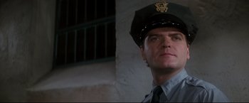 Movie still from “Superman II” (1980), directed by Richard Lester – A man wearing a uniform and a hat; Close Up shot, Low angle