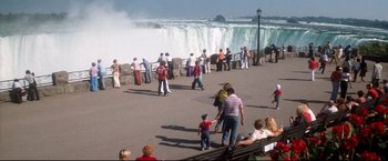 Movie still from “Superman II” (1980), directed by Richard Lester – A group of people standing on the side of a river; Extreme Wide shot, High angle
