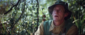 Movie still from “Superman II” (1980), directed by Richard Lester – An older man wearing a hat and a green vest; Close Up shot, Low angle