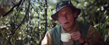 Movie still from “Superman II” (1980), directed by Richard Lester – A man holding a cup in his hand; Medium shot, Over the shoulder angle