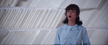 Movie still from “Superman II” (1980), directed by Richard Lester – A woman in a blue shirt is looking surprised; Medium shot, Low angle