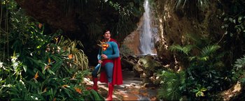 Movie still from “Superman II” (1980), directed by Richard Lester – A man dressed as superman posing in front of a waterfall; Wide shot, Low angle