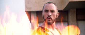 Movie still from “Superman II” (1980), directed by Richard Lester – A man with a beard is in front of a fire; Close Up shot, Low angle