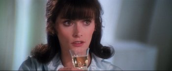 Movie still from “Superman II” (1980), directed by Richard Lester – A person holding a glass of wine; Close Up shot, Over the shoulder angle