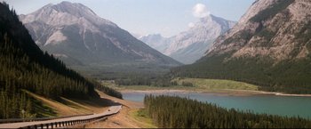 Movie still from “Superman II” (1980), directed by Richard Lester – A view of a mountain valley with a road going through it; Extreme Wide shot, High angle