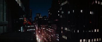 Movie still from “Superman II” (1980), directed by Richard Lester – A view of a city street at night with lights on; Extreme Wide shot, Low angle