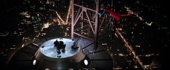 Movie still from “Superman II” (1980), directed by Richard Lester – A man flying through the air while riding a parachute; Extreme Wide shot, Overhead angle