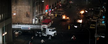 Movie still from “Superman II” (1980), directed by Richard Lester – A truck that is on fire in the middle of the street; Extreme Wide shot, High angle