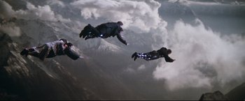 Movie still from “Superman II” (1980), directed by Richard Lester – A group of skydivers flying through the air; Extreme Wide shot, Overhead angle