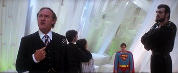 Movie still from “Superman II” (1980), directed by Richard Lester – A group of people standing next to each other in a room; Medium shot, Over the shoulder angle