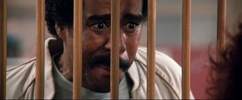 Movie still from “Superman III” (1983), directed by Richard Lester – A person behind a wooden fence; Close Up shot, High angle