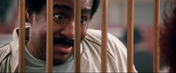 Movie still from “Superman III” (1983), directed by Richard Lester – A person behind a wooden fence; Close Up shot, High angle