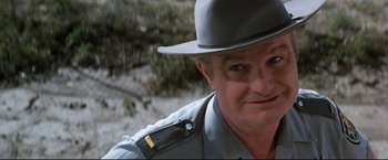 Movie still from “Superman III” (1983), directed by Richard Lester – A person wearing a hat; Close Up shot, Over the shoulder angle