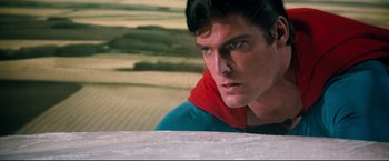 Movie still from “Superman III” (1983), directed by Richard Lester – A young man in a superman costume looks at the camera; Close Up shot, Low angle