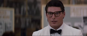 Movie still from “Superman III” (1983), directed by Richard Lester – A person wearing glasses and a bow tie; Close Up shot, Over the shoulder angle