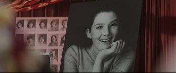 Movie still from “Superman III” (1983), directed by Richard Lester – An old photo of a woman smiling with her hand on her chin; Extreme Close Up shot, Low angle