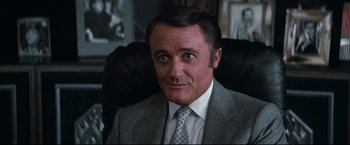 Movie still from “Superman III” (1983), directed by Richard Lester – A person wearing a suit and tie; Close Up shot, Low angle