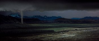 Movie still from “Superman III” (1983), directed by Richard Lester – A view of a mountain range in the distance with a dark sky above it; Extreme Wide shot, High angle