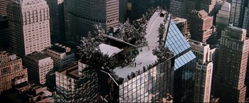 Movie still from “Superman III” (1983), directed by Richard Lester – A view of a building from above with trees growing on it's roof; Extreme Wide shot, High angle