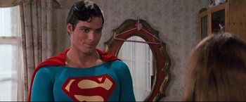 Movie still from “Superman III” (1983), directed by Richard Lester – A man dressed as superman in front of a mirror; Medium shot, Over the shoulder angle