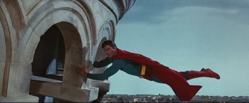 Movie still from “Superman III” (1983), directed by Richard Lester – A man dressed as superman is climbing a wall; Medium shot, Low angle