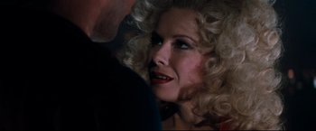 Movie still from “Superman III” (1983), directed by Richard Lester – A person with curly blonde hair; Close Up shot, Over the shoulder angle