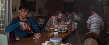 Movie still from “Superman III” (1983), directed by Richard Lester – A group of people sitting at a long table; Medium shot, Over the shoulder angle