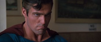 Movie still from “Superman III” (1983), directed by Richard Lester – A person wearing a superman costume; Close Up shot, Over the shoulder angle