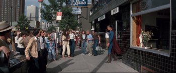 Movie still from “Superman III” (1983), directed by Richard Lester – A group of people walking down a street; Wide shot, High angle