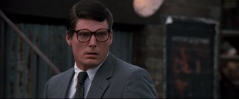 Movie still from “Superman III” (1983), directed by Richard Lester – A person wearing glasses and a suit; Close Up shot, Over the shoulder angle