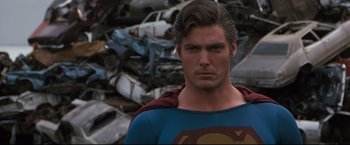 Movie still from “Superman III” (1983), directed by Richard Lester – A man that is wearing a superman costume; Close Up shot, Over the shoulder angle