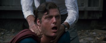 Movie still from “Superman III” (1983), directed by Richard Lester – A man with his mouth wide open being held by another man; Close Up shot, Low angle