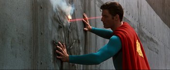 Movie still from “Superman III” (1983), directed by Richard Lester – A man in a superman costume is holding a laser beam; Medium shot, Low angle