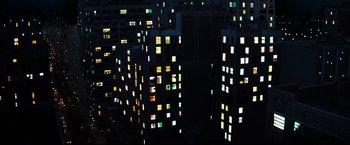 Movie still from “Superman III” (1983), directed by Richard Lester – A view of a city at night with many windows lit up; Extreme Wide shot, Overhead angle