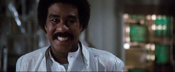 Movie still from “Superman III” (1983), directed by Richard Lester – A person wearing a white shirt; Close Up shot, Low angle