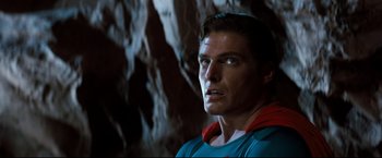 Movie still from “Superman III” (1983), directed by Richard Lester – A person wearing a superman costume; Close Up shot, Over the shoulder angle