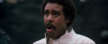 Movie still from “Superman III” (1983), directed by Richard Lester – A person with a beard looking surprised; Close Up shot, Low angle