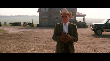 Movie still from “Superman IV: The Quest for Peace” (1987), directed by Sidney J. Furie – A man in a cowboy hat standing in front of a barn; Medium shot, Over the shoulder angle