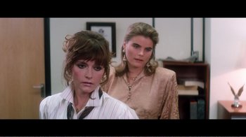 Movie still from “Superman IV: The Quest for Peace” (1987), directed by Sidney J. Furie – Two women standing next to each other in front of a wall; Medium shot, Over the shoulder angle