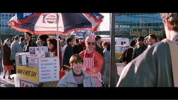 Movie still from “Superman IV: The Quest for Peace” (1987), directed by Sidney J. Furie – A man and a boy are standing in front of a crowd; Medium shot, Over the shoulder angle