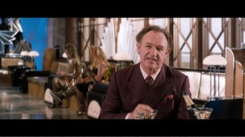 Movie still from “Superman IV: The Quest for Peace” (1987), directed by Sidney J. Furie – A man in a suit and tie holding a glass of wine; Medium shot, Over the shoulder angle