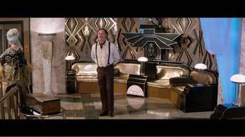 Movie still from “Superman IV: The Quest for Peace” (1987), directed by Sidney J. Furie – A man in a suit and tie standing in a living room; Wide shot, High angle