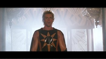 Movie still from “Superman IV: The Quest for Peace” (1987), directed by Sidney J. Furie – A man in a star costume standing in front of a wall; Medium shot, Low angle